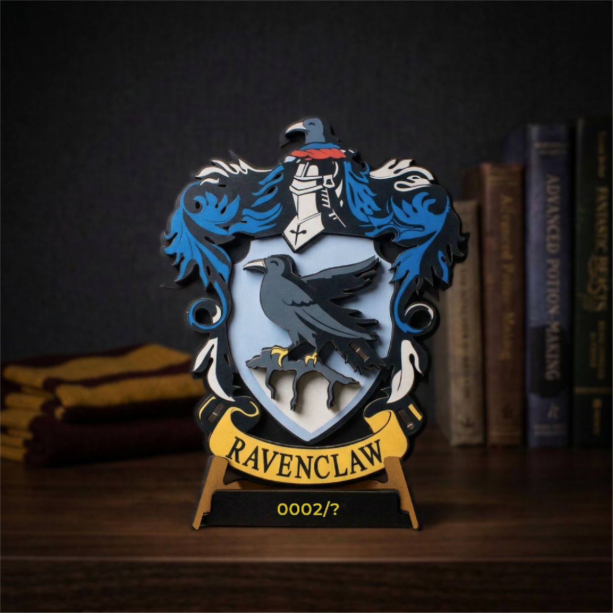 Ravenclaw wooden house crest with its layered shield, displayed beside books on a desk