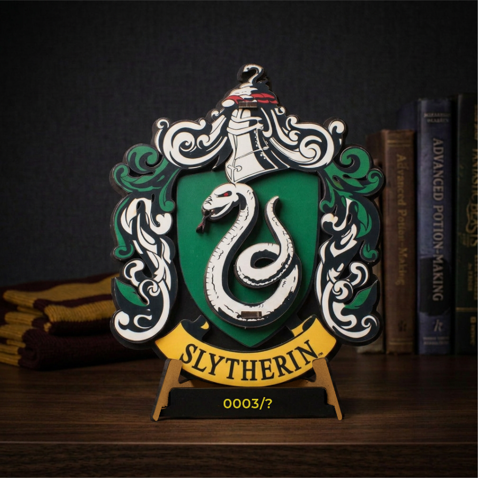 Slytherin wooden house crest with its serpent shield, displayed beside books on a desk