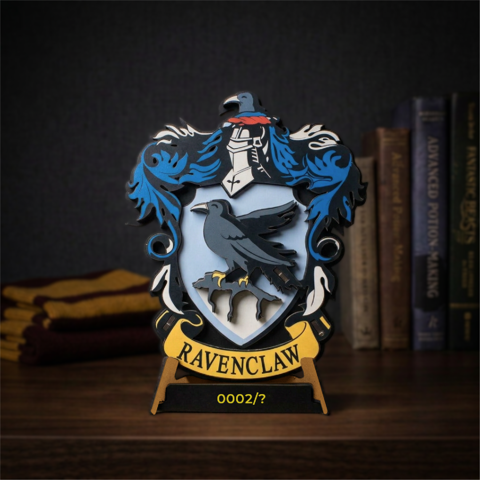 Ravenclaw wooden house crest with its layered shield, displayed beside books on a desk