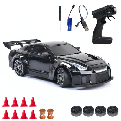 Black RC car with remote control, battery, and accessories on a white background
