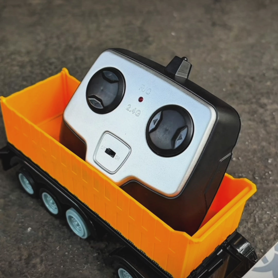 Two RC Black and White Trucks with it's Remote control on it's truck bed.